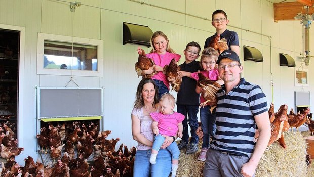 Patrizia und Christian Bamert-Weishaupt mit ihren Kindern Jonas, Angelika, Reto, Lilian und Andreina, umgeben von ihren Legehennen. Neben Hühnern halten sie auch Rinder und Milchkühe. 
